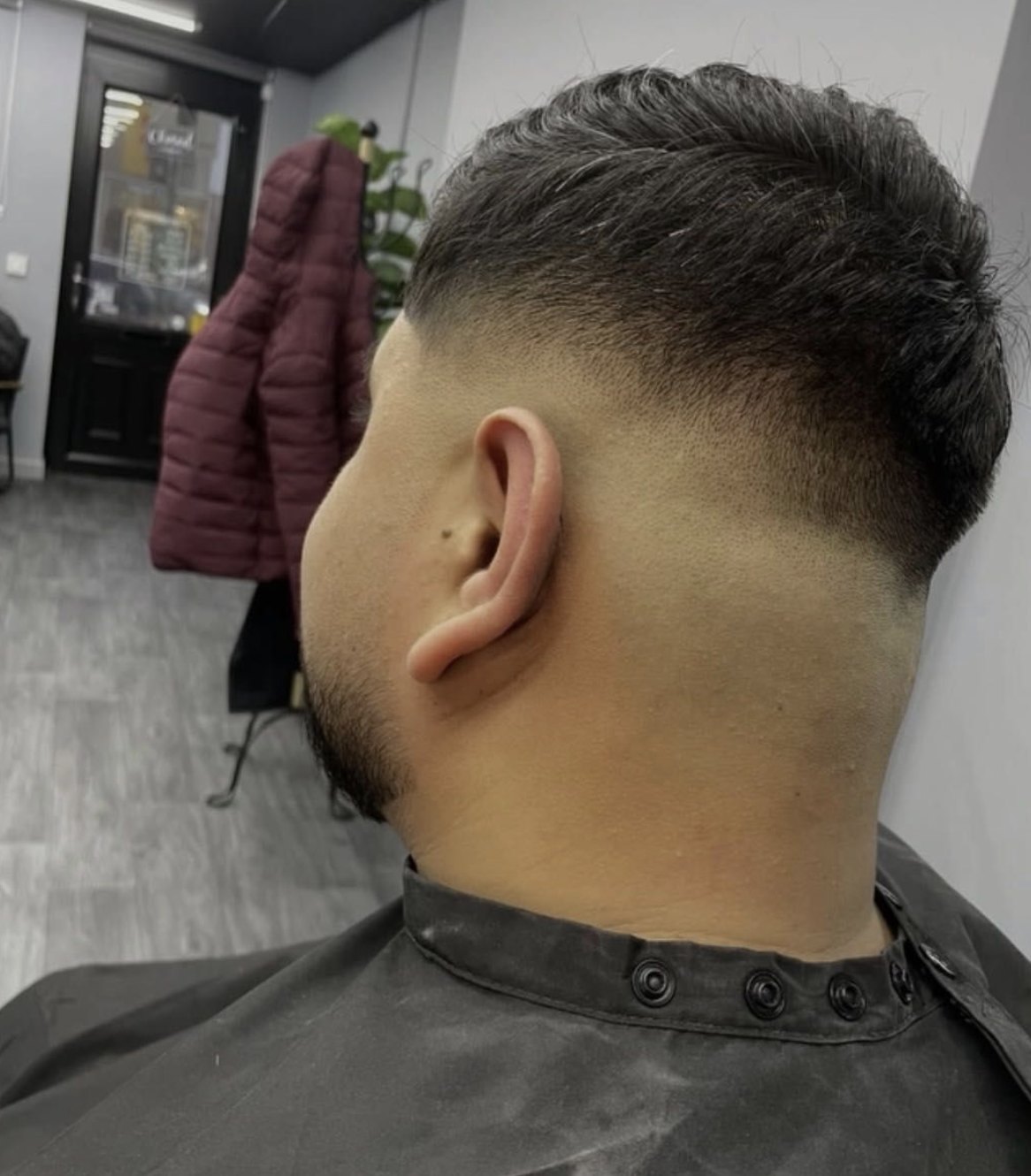 Close-up of a sharp skin fade with a textured top